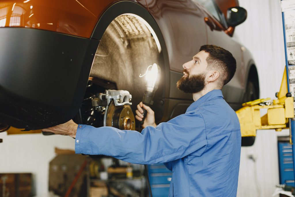 close up of a certified Ford technician changing out brakes.