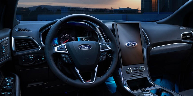 The interior of a 2024 Ford Edge, featuring a steering wheel and a dashboard. The steering wheel is positioned in the center of the image, with the dashboard visible in the background. The car appears to be well-maintained and ready for a thrilling driving experience.